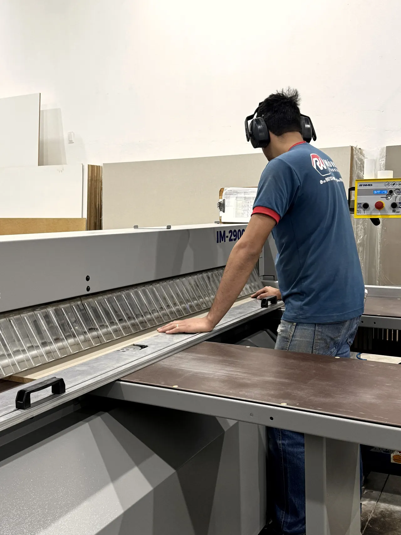 Operador na seccionadora industrial cortando chapas na fábrica da RW